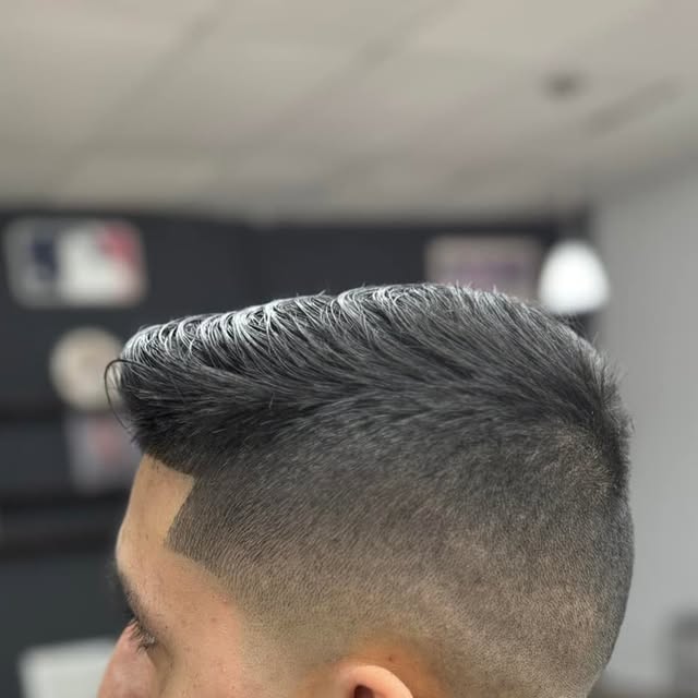 Close-up haircut result with fade and styled top