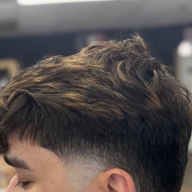Close-up haircut result with tapered side and textured top